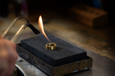 Cropped hands of person using blow torch to make jewelry