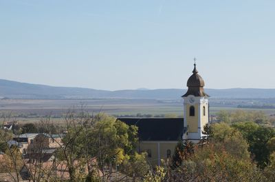 Church by building against clear sky