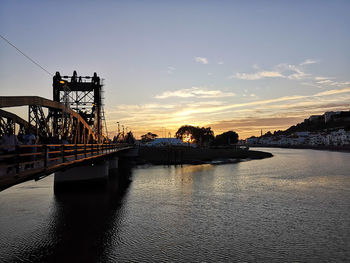 Bridge over river against sky during sunset