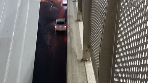 Person standing on railing against wall