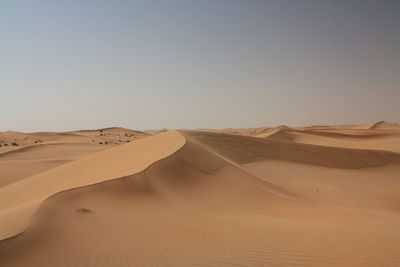 Scenic view of sand dune against clear sky