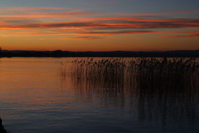 Scenic view of lake against orange sky