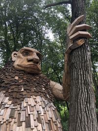 Low angle view of statue against tree trunk