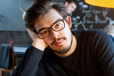 Close-up portrait of young man wearing eyeglasses