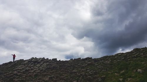 Low angle view of mountain against cloudy sky