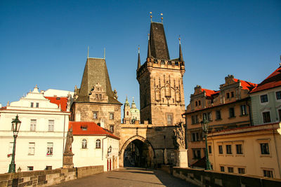 View of buildings in city against clear blue sky