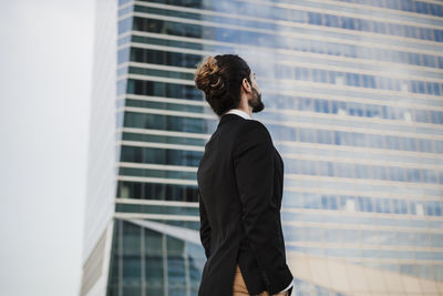 Man with umbrella standing against building