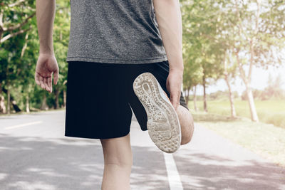 Low section of woman walking on road