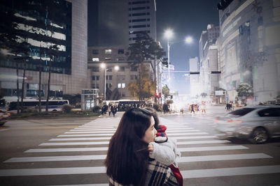 Young woman crossing road in city