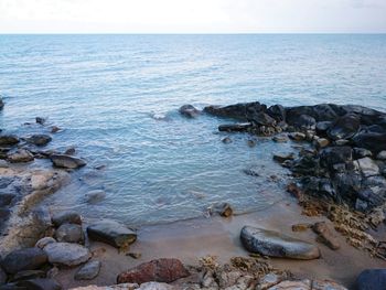 Scenic view of rocks in sea against sky