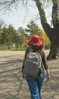 Rear view of woman with umbrella walking in park