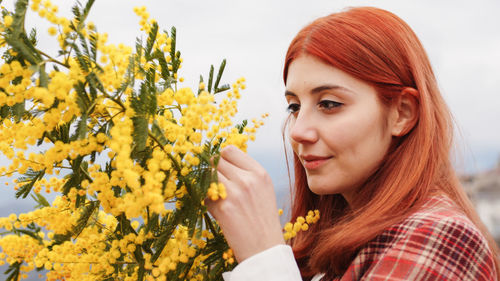 Young girl celebrates women's day with yellow mimosa flowers in hand