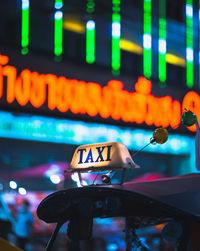 Close-up of illuminated lighting equipment in city at night