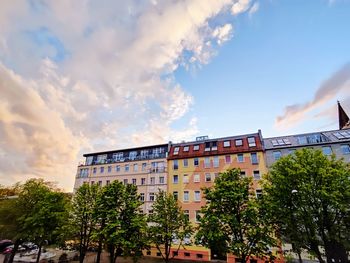 Low angle view of buildings and trees against sky