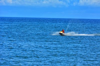 People on boat in sea against sky