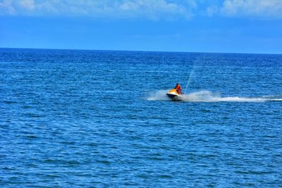 Man motorboating in sea against sky