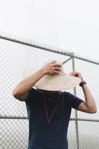 Midsection of man holding umbrella against sky