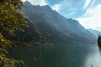 Scenic view of lake by mountains against sky