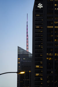 Illuminated buildings against clear sky at night