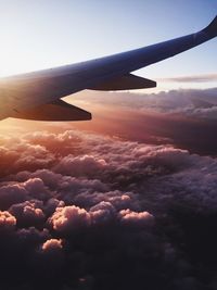 Aerial view of airplane wing over clouds