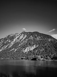 Scenic view of snowcapped mountains by sea against clear sky