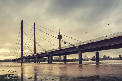 Bridge over river against cloudy sky