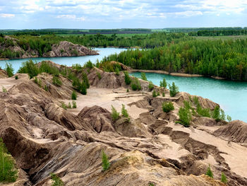 Scenic view of rocks by river against sky