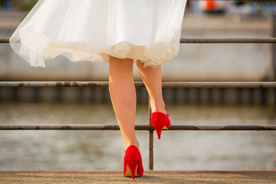 Low section of woman standing on bridge