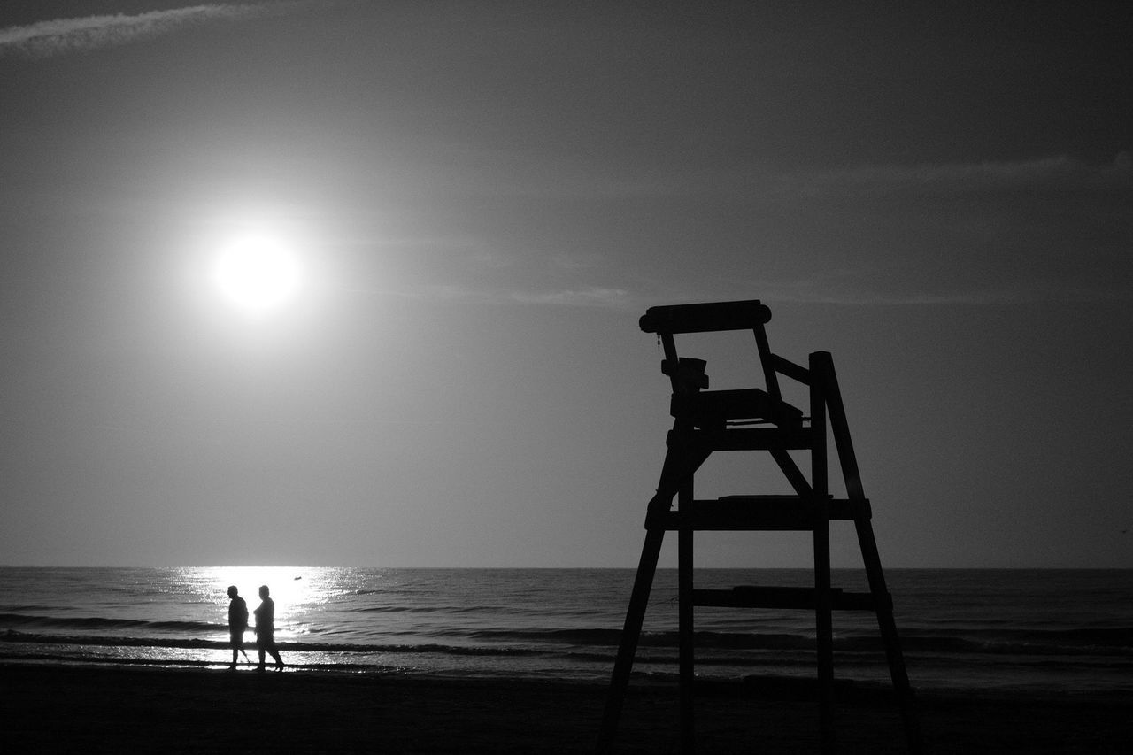 sea, horizon over water, water, silhouette, beach, sun, scenics, sky, tranquility, tranquil scene, beauty in nature, nature, leisure activity, sunlight, lifestyles, shore, sunset, men, standing