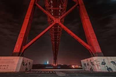 Low angle view of illuminated bridge against sky at night