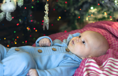 Portrait of cute girl lying on christmas tree