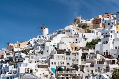 Scenic view of oia with its typical windmill and white house, santorini, greece