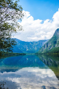 Scenic view of lake and mountains against blue sky