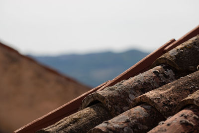 Close-up of rusty railing against mountain against sky