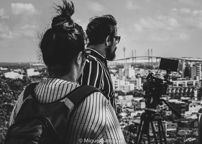 Rear view of couple kissing against sky