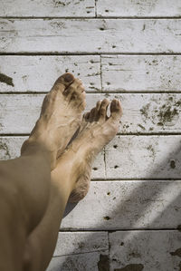 Low section of person relaxing on wooden floor