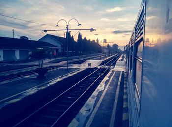 Railroad tracks against sky during sunset