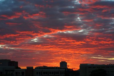 Low angle view of buildings against dramatic sky
