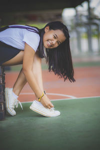 Young woman smiling while sitting outdoors