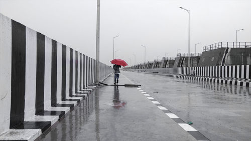 Boy walking on wet road during monsoon