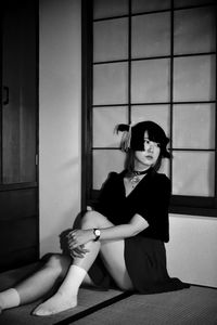 Portrait of woman sitting on floor at home