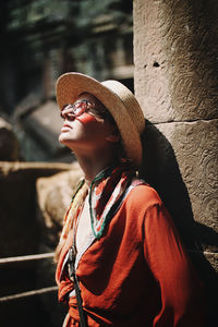 Side view of woman standing against wall