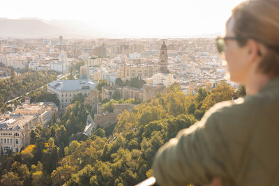 Side view of man looking at cityscape