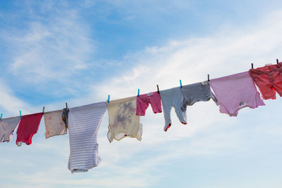 Low angle view of clothes drying on clothesline against sky