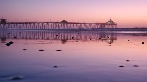 Pier over sea against clear sky during sunset