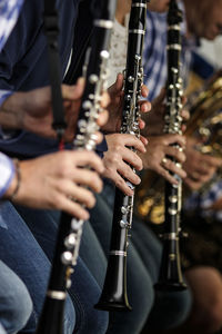 Midsection of musicians playing wind instrument