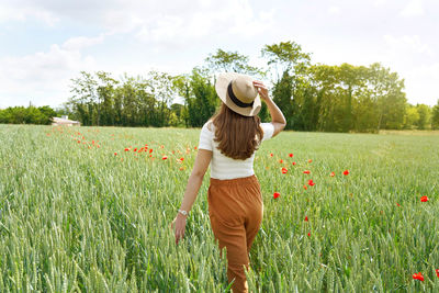 Rear view of woman on field against sky