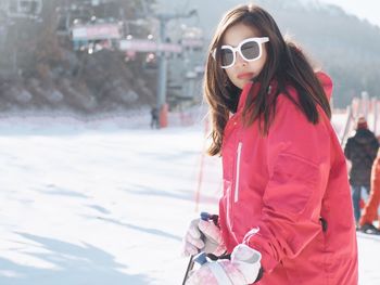 Side view of young woman skiing on snow covered field