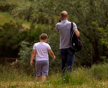 Rear view of men walking on field