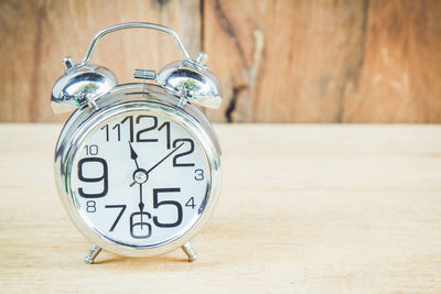 Close-up of alarm clock on wooden table